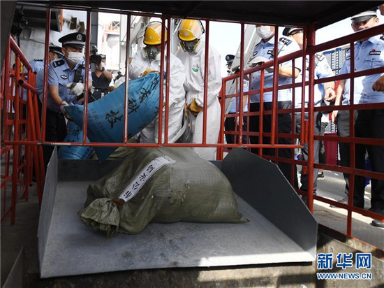 工作人员将毒品投入高温焚烧炉进行销毁